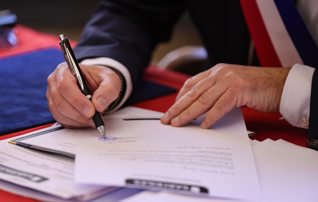 a-person-signs-a-document-with-a-pen-iz0q3qtqvju